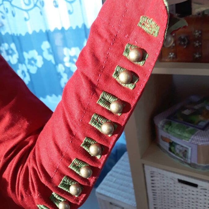 Female Medieval red gown: detail of the sleeve buttons