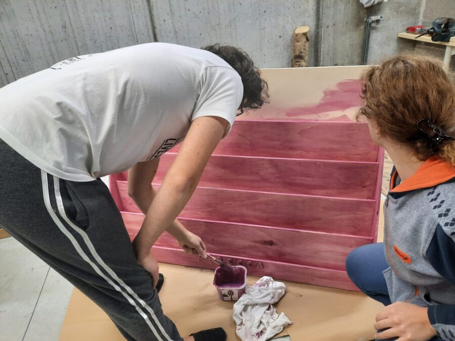 Locutus and Rici painting the Montessori bookshelf pink