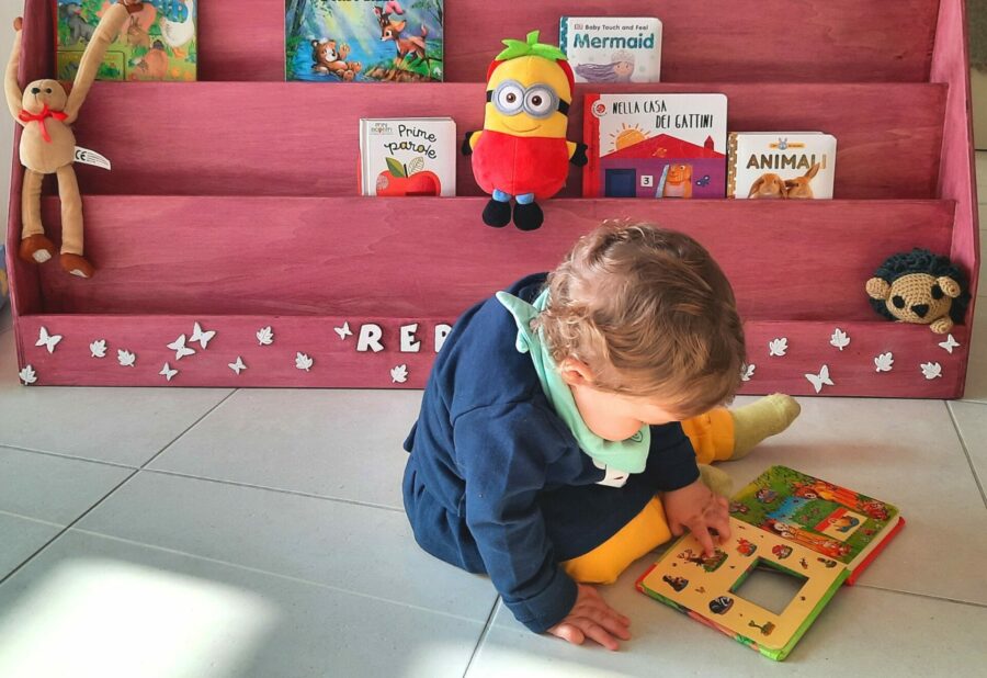 Our toddler discovering her Montessori bookshelf