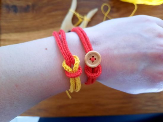Lucetted bracelets: red and yellow with decorative knot; red with wooden button