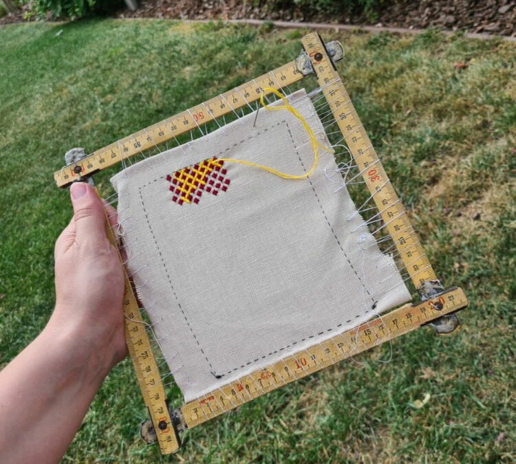 The folding ruler embroidery frame with my German brick stitch project mounted on