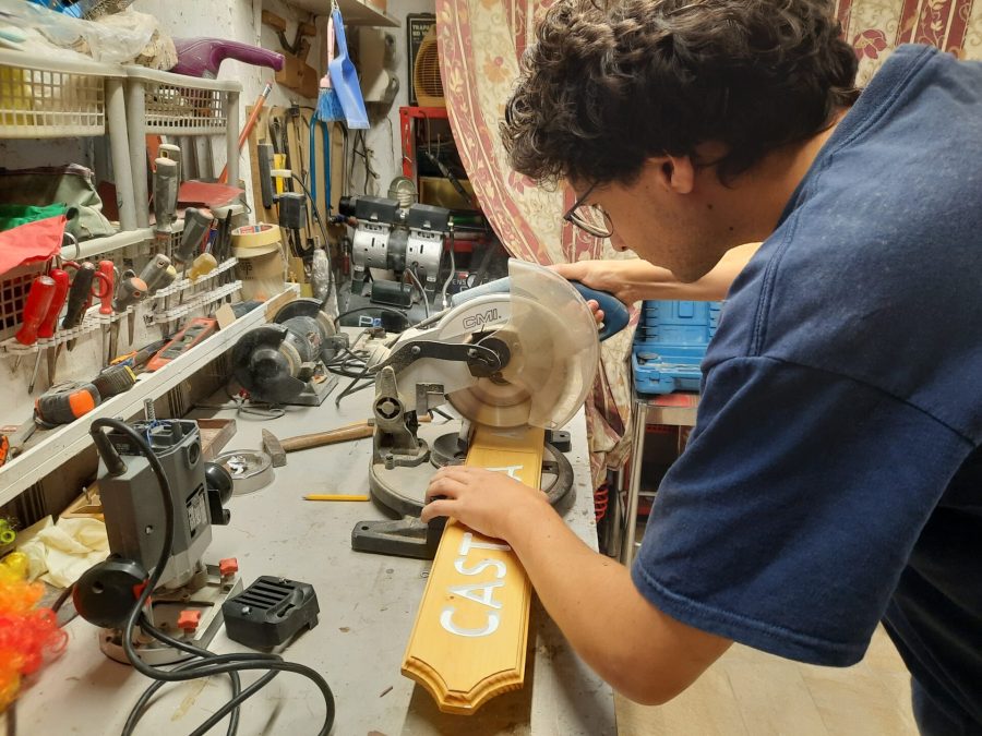 Splitting the wooden sign into two halves: cutting