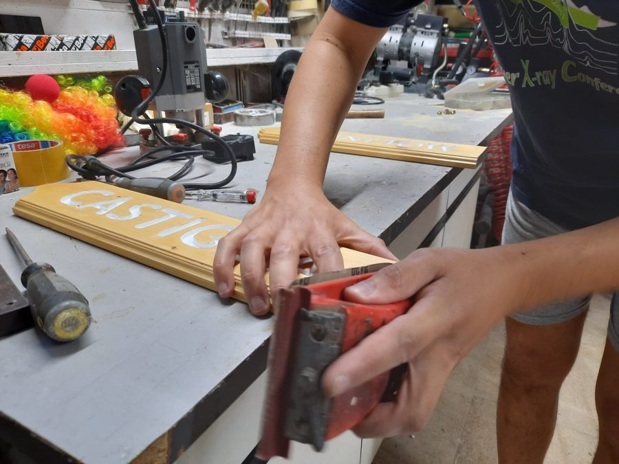 Splitting the wooden sign into two halves: sanding