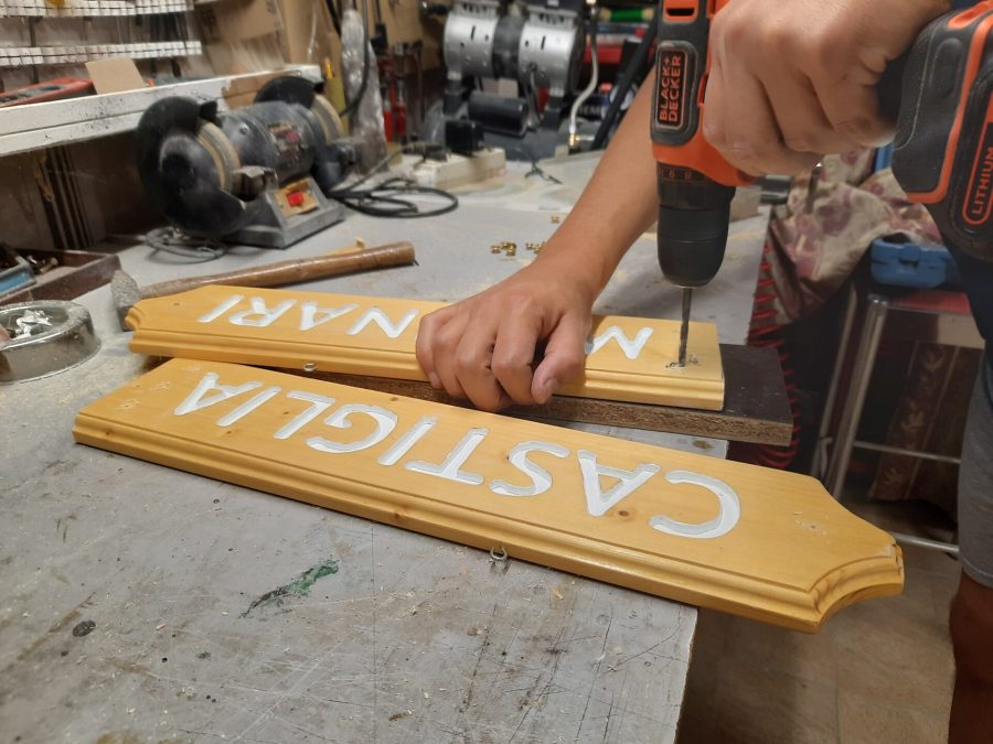 Splitting the wooden sign into two halves: drilling the holes for the cord