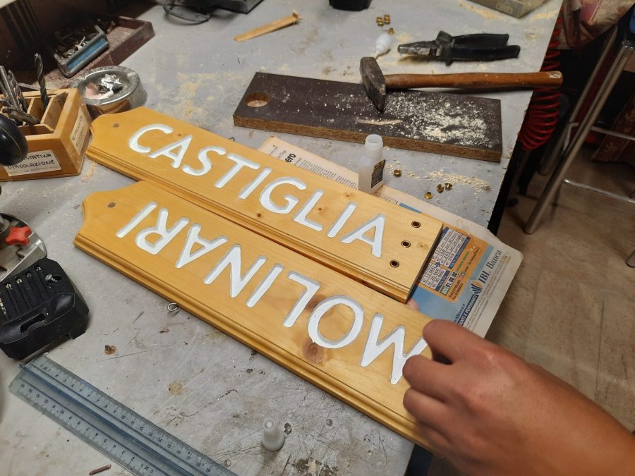 Splitting the wooden sign into two halves: adding metal eyelets to the holes for the cord