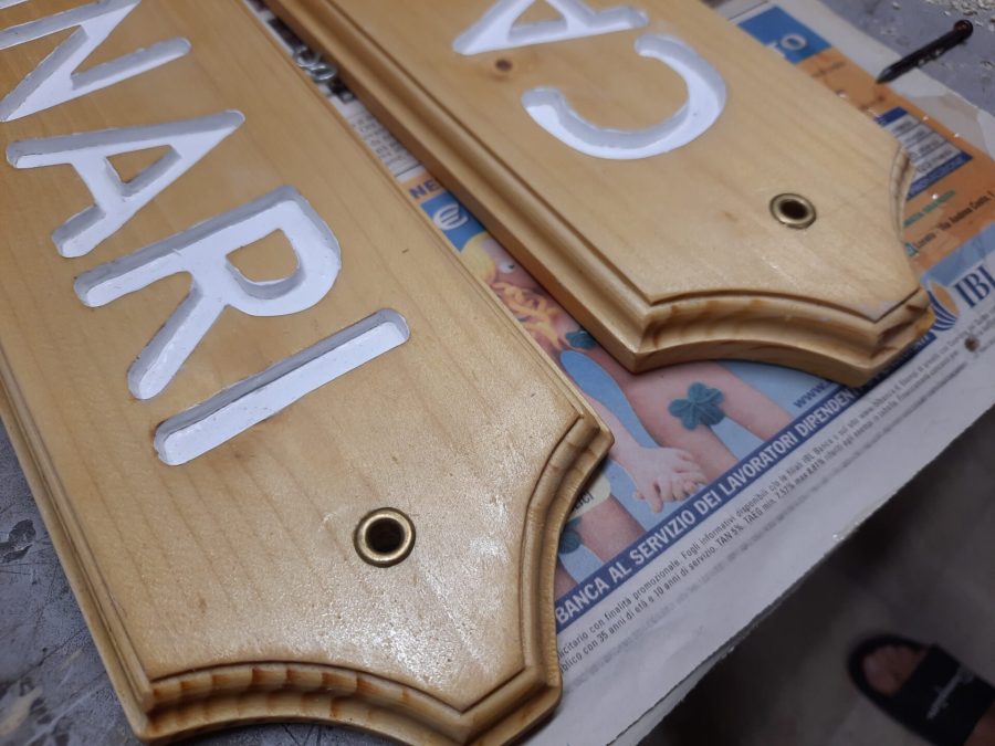 Splitting the wooden sign into two halves: adding metal eyelets to the holes for the cord