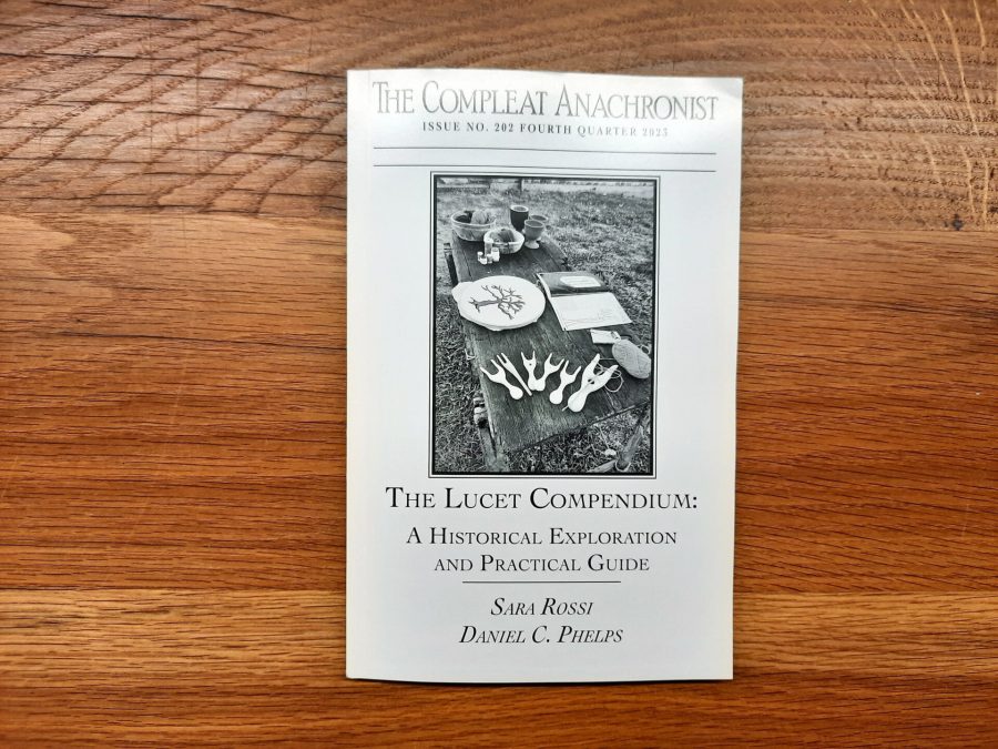 Printed copy of "The Lucet Compendium: a historical exploration and practical guide", book by Sara Rossi and Daniel Craig Phelps about the history of the lucet with practical guidance for modern crafters.