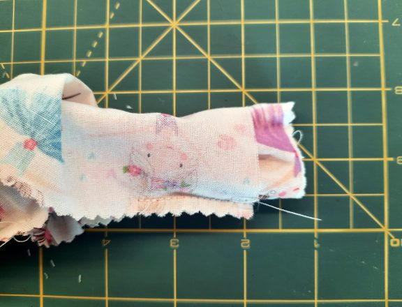 Sewing a scrunchie: turn the tube of fabric halfway right so the short sides match