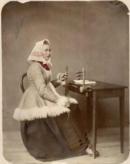 Hårkulla, dressed in folk costume from Dalarna, works with hair work. Hand-colored photo, ca. 1880 - 1900