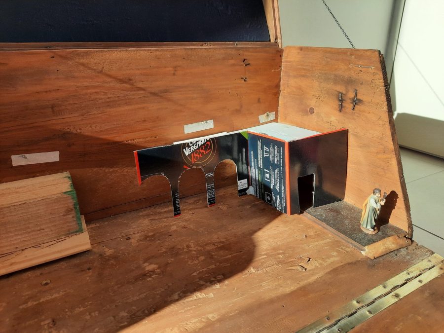 Testing the buildings' cardboard models for the Christmas nativity diorama inside the steamer trunk, with the new resin statues