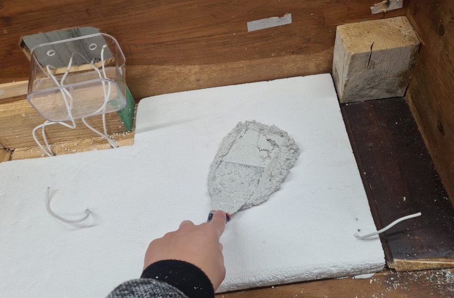 Making the landscape for our Christmas nativity diorama inside the steamer trunk: the cement coating