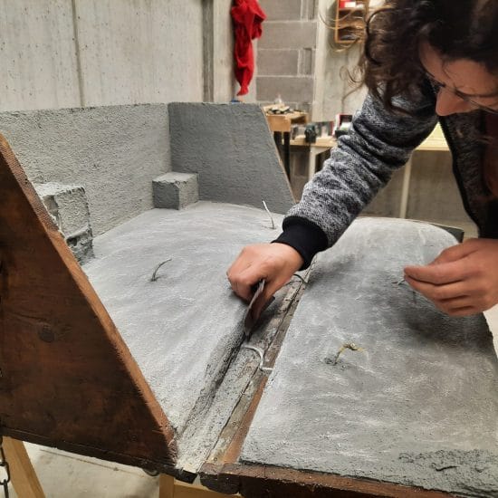 Making the landscape for our Christmas nativity diorama inside the steamer trunk: the cement coating