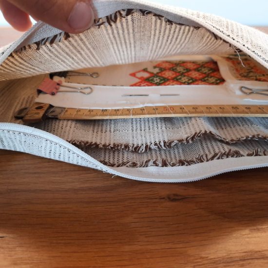 Travel bag to carry an embroidery project. Detachable strap, inner compartments, inner pocket, inner elastic band for tools.