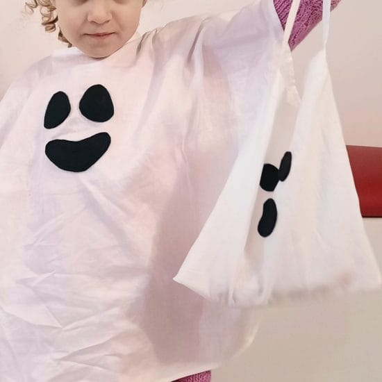 My daughter showing off her ghostly candy bag matching her ghost cape