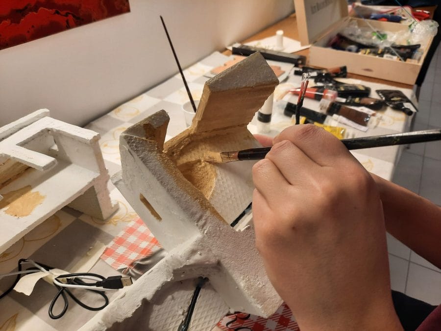 Making a Nativity diorama inside an antique steamer trunk: the first touch of color on the buildings