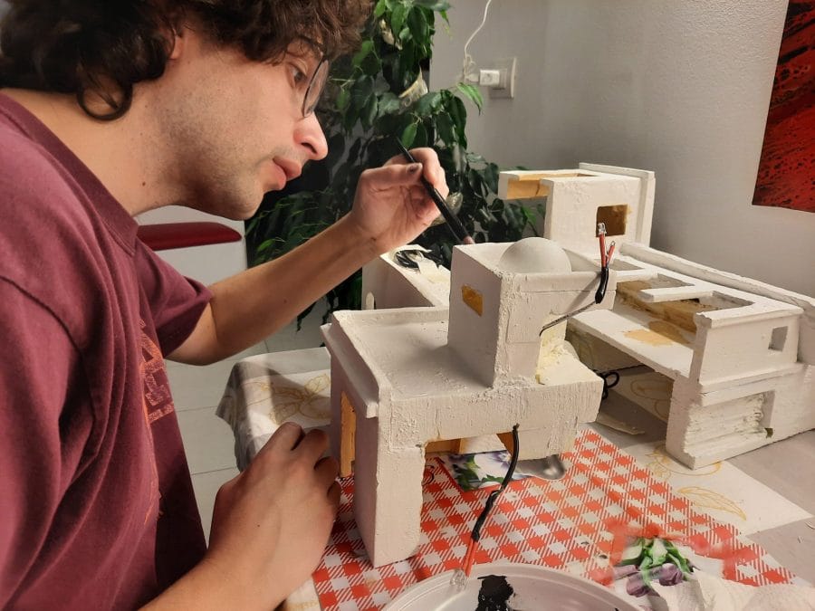 Making a Nativity diorama inside an antique steamer trunk: the first touch of color on the buildings