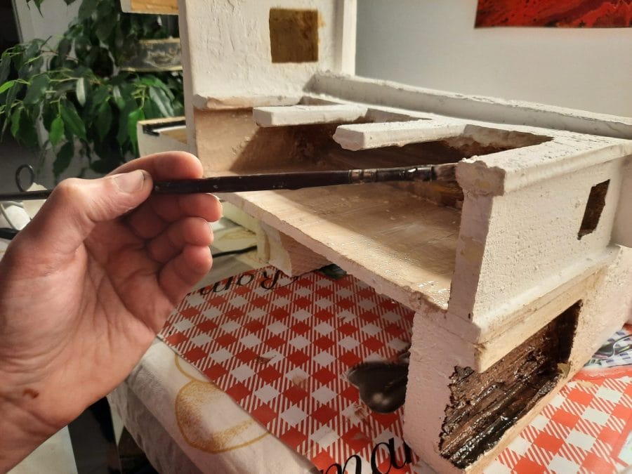 Making a Nativity diorama inside an antique steamer trunk: the first touch of color on the buildings