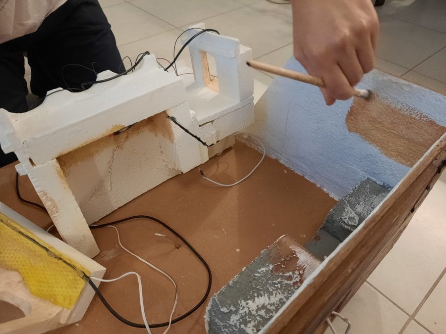 Making a Nativity diorama inside an antique steamer trunk: the first touch of color on the buildings