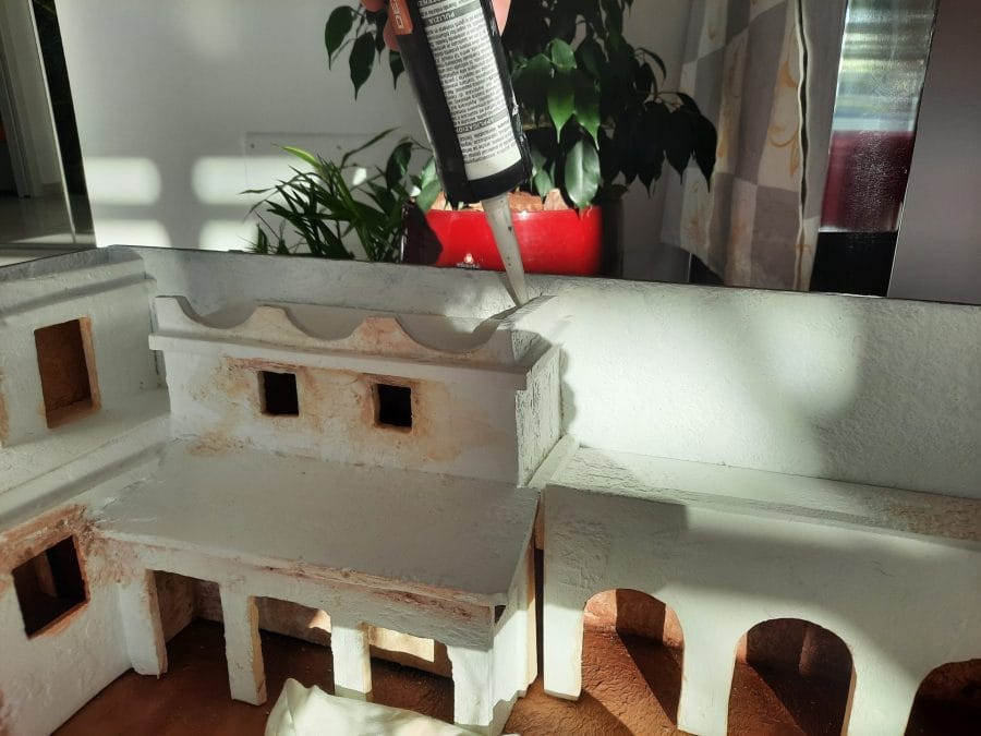 Making a Nativity diorama inside an antique steamer trunk: fixing the buildings in place