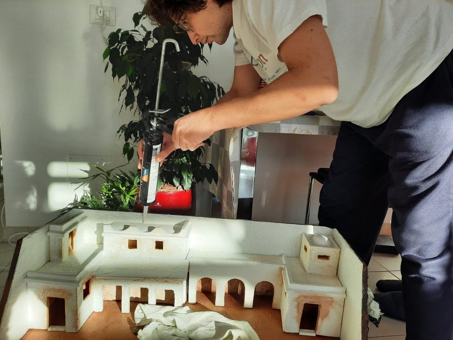 Making a Nativity diorama inside an antique steamer trunk: fixing the buildings in place