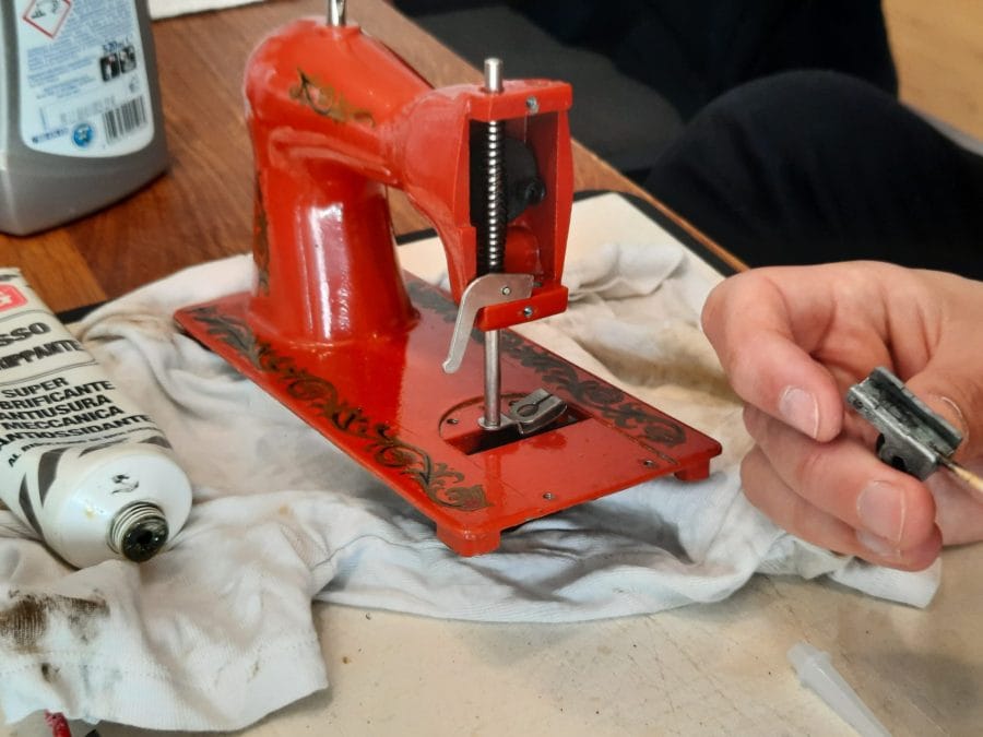 Putting grease on the inner mechanisms of the second Orsha sewing machine
