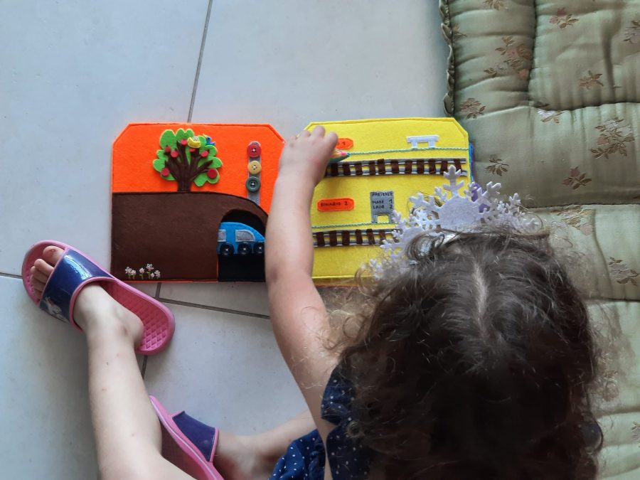 MJy daughter playin with her felt busy book "Train trip to the seaside"