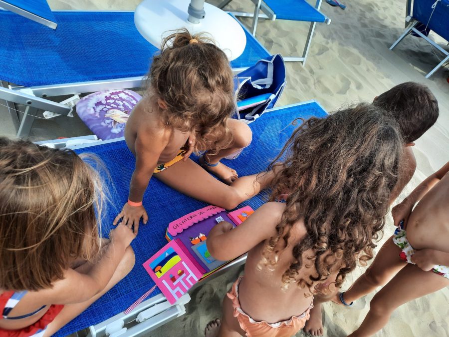 MJy daughter playin with her felt busy book "Train trip to the seaside", showing it to her beach friends