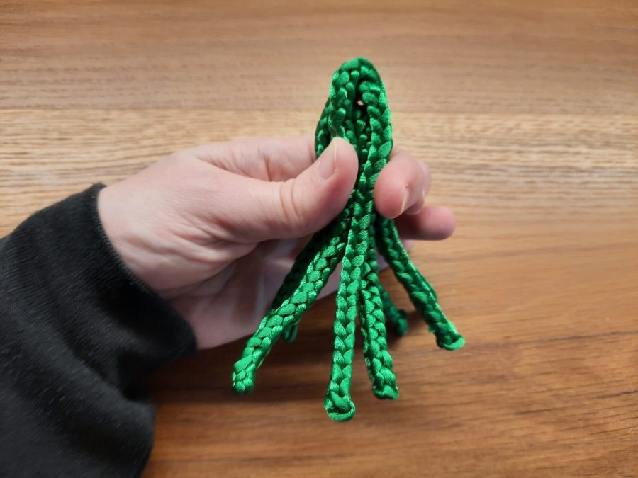 Making the octopus toy with the lucet: fold all your cords together, keeping the midpoints on top, in a compact bundle
