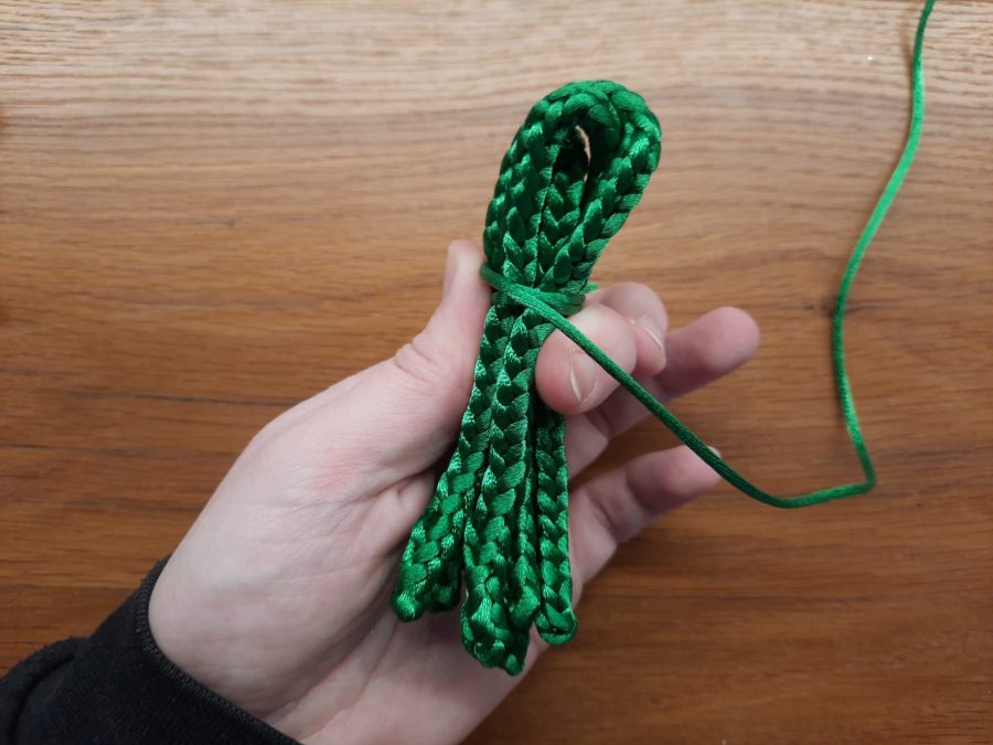 Making the octopus toy with the lucet: at the point where you want the head to finish and the tentacles to begin, wrap the bundle with yarn and secure