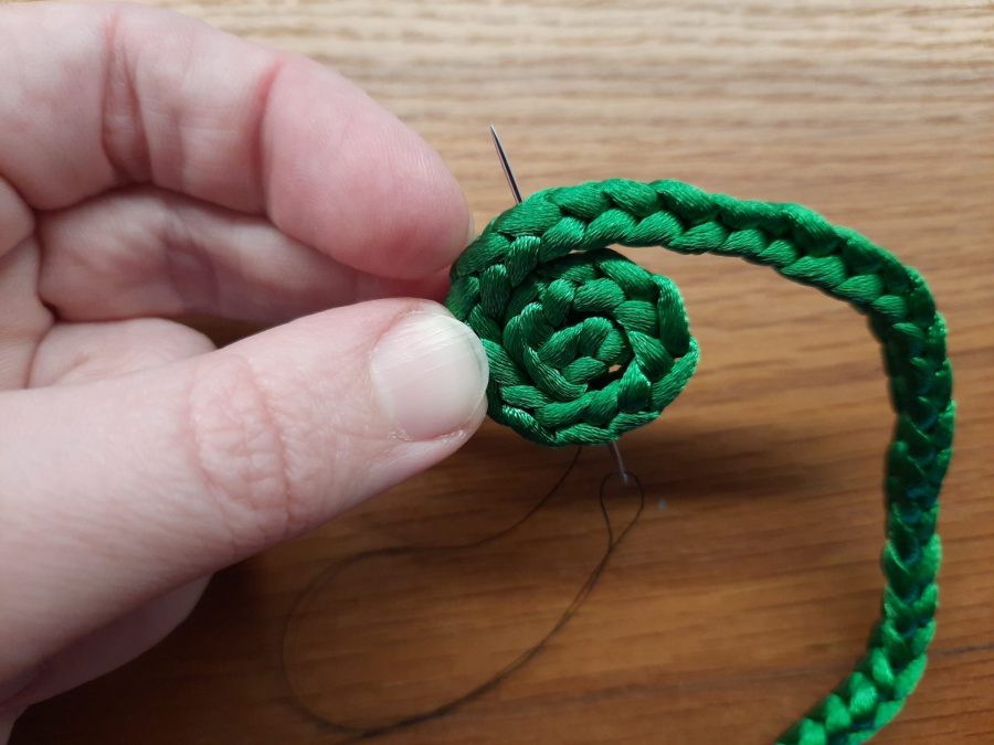 Making the snail toy with the lucet: sew a spiral to make the shell