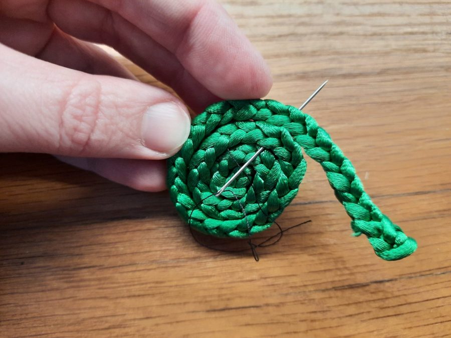 Making the snail toy with the lucet: sew a spiral to make the shell
