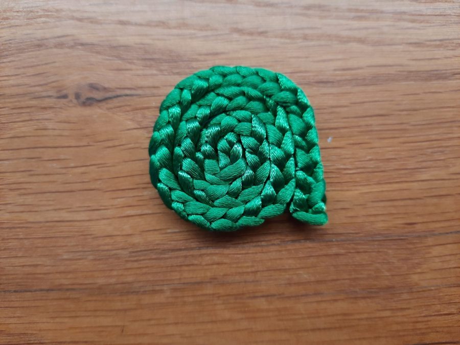 Making the snail toy with the lucet: sew a spiral to make the shell