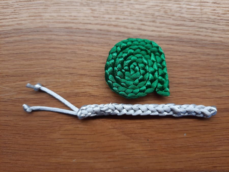 Making the snail toy with the lucet: sew together body and shell to assemble and finish