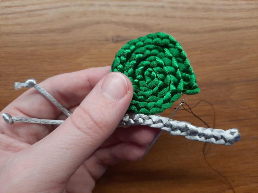 Making the snail toy with the lucet: sew together body and shell to assemble and finish