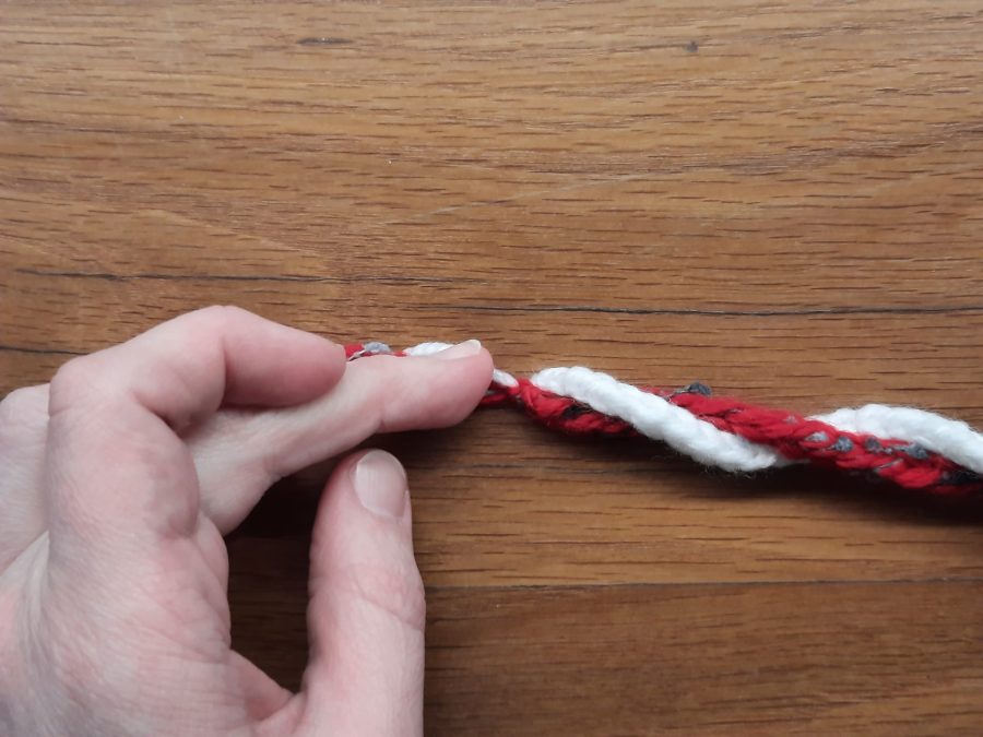 How to make a toy lollipop with the lucet: start wrapping the two cords together in a spiral