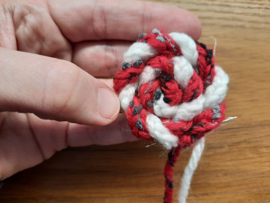 How to make a toy lollipop with the lucet: as you twist the cords, sew them in place in a spiral